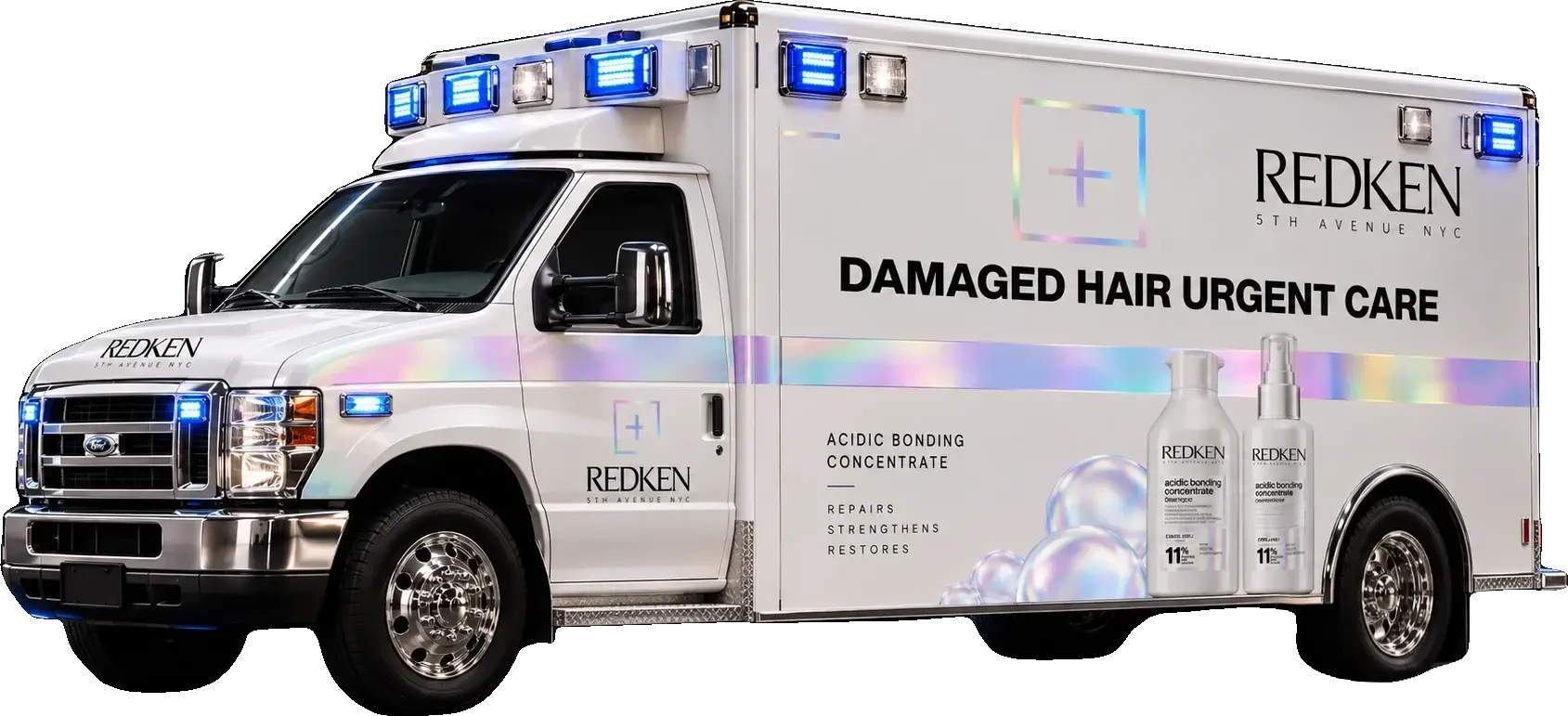 Damage Dispatch: a white Redken ambulance in iridescent livery, blue beacons lit, seen three-quarter from the front, reading DAMAGED HAIR URGENT CARE above Acidic Bonding Concentrate &mdash; repairs, strengthens, restores.
